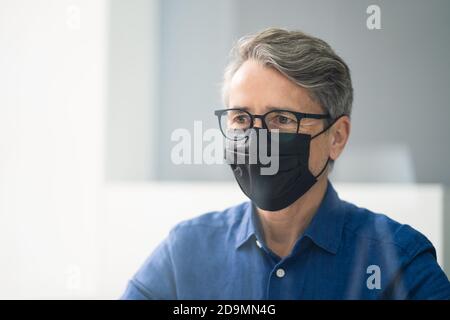 Receptionist in maschera presso il Medical Center Covid Office Foto Stock