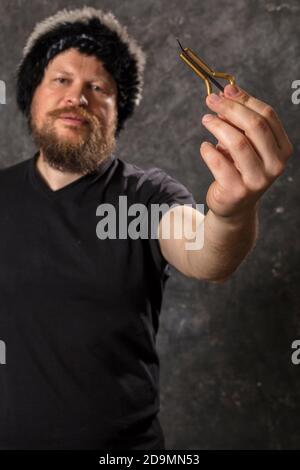 Uomo maturo in pelliccia cappello che gioca ebrei arpa ritratto studio Foto Stock