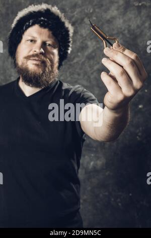 Uomo maturo in pelliccia cappello che gioca ebrei arpa ritratto studio Foto Stock