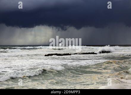 Tempesta di mare con pioggia e onde all'ingresso del porto, Povoa de Varzim, nord del Portogallo. Foto Stock