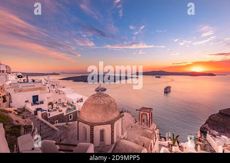 Fantastica vista serale dell'isola di Santorini, magico paesaggio estivo al tramonto della baia del mare con cielo colorato, barche da crociera sulla famosa architettura bianca Foto Stock