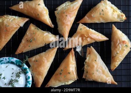 Cucina greca. Tiropita con formaggio feta e pasta fillo su fondo scuro. Vista dall'alto. Foto Stock