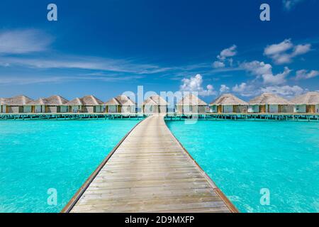 Paesaggio panoramico della spiaggia Maldive. Panorama tropicale, resort di lusso con ville d'acqua con molo o molo in legno. Sfondo di destinazione di viaggio di lusso Foto Stock