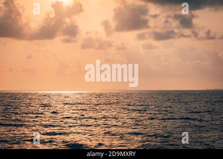 Mare calmo con cielo tramonto e sole attraverso le nuvole sopra. Meditazione vibrazioni positive oceano cielo sfondo. Mare tranquillo. Orizzonte sull'acqua. Foto Stock