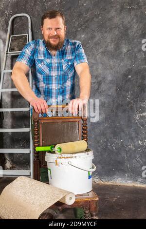 Gioioso caposquadra in pantaloni verdi con studio di utensili da lavoro verticale Foto Stock