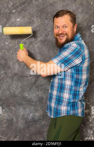 Gioioso caposquadra in pantaloni verdi con studio di utensili da lavoro verticale Foto Stock