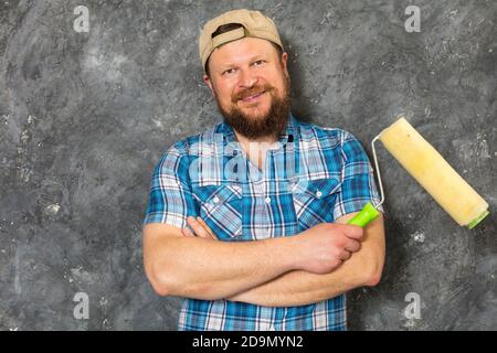 Gioioso caposquadra in pantaloni verdi con studio di utensili da lavoro verticale Foto Stock