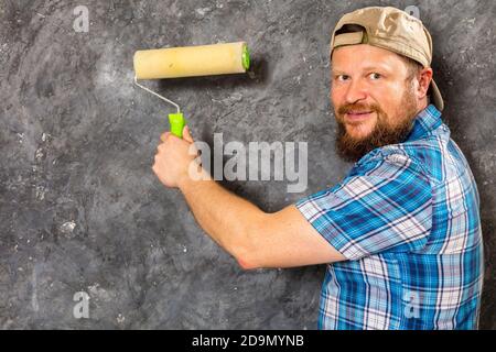 Gioioso caposquadra in pantaloni verdi con studio di utensili da lavoro verticale Foto Stock