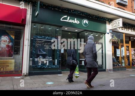 Windsor, Regno Unito. 6 novembre 2020. I residenti locali passano davanti a un ramo di Clarks, una delle catene di scarpe più antiche del Regno Unito, il secondo giorno del secondo blocco del coronavirus inglese. Clarks è stato salvato per mezzo di un investimento di £100 milioni dalla società di private equity LionRock Capital con sede a Hong Kong e ora entrerà in un accordo volontario di società (CVA). Credit: Mark Kerrison/Alamy Live News Foto Stock