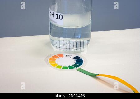 Striscia di prova con grafico a colori della carta di tornasole per determinare il acidità di un liquido Foto Stock