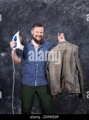 Uomo solido bearded a vestiti casual che si diverte con il ferro ritratto emotivo in studio Foto Stock