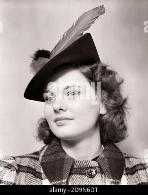 1940 ANNI RITRATTO SORRIDENTE GIOVANE DONNA TEEN INDOSSANDO PLAID DI LANA CAPPOTTO E CAPPELLO JAUNTY CON PIUMA GRANDE - G1753 HAR001 HARS LIFESTYLE FEMES STUDIO COPIA SPAZIO SIGNORE PERSONE ADOLESCENTE RAGAZZA PLAID FIDUCIA B&W BRUNETTE FELICITÀ STILE TESTA E SPALLE ED ELEGANTI TEENAGED MODA DI LANA GIOVANI DONNE ADULTE GIOVANI NERE E BIANCO ETNIA CAUCASICA HAR001 VECCHIO STILE Foto Stock