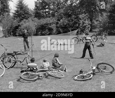 ANNI '50 GRUPPO DI RAGAZZI CHE GIOCANO A BADMINTON ALL'APERTO SDRAIATO IN ERBA CON BICICLETTE - J4959 HAR001 HARS SANA AMICO NET BADMINTON CONCORRENZA COTONE ATLETA STILE DI VITA FEMMINILE CICLISMO RURALE SANO COPIA SPAZIO AMICIZIA LUNGHEZZA INTERA MEZZA FORMA FISICA PERSONE ISPIRAZIONE MASCHI ADOLESCENTI RAGAZZA ADOLESCENTE RAGAZZO ATLETICO BICICLETTE DENIM TRASPORTO B&W BICICLETTE ESTATE ATTIVITÀ 8 BENESSERE FISICO, AVVENTURA AD ALTO ANGOLO, DIVERTIMENTO, FORZA RACCHETTE RICREAZIONE FLESSIBILITÀ AMICHEVOLE MUSCOLI SHUTTLECOCK TEENAGED JEANS BLU COOPERAZIONE OTTO GIOVANI INFORMALI DI CRESCITA PRE-TEEN RAGAZZO PRE-TEEN Foto Stock