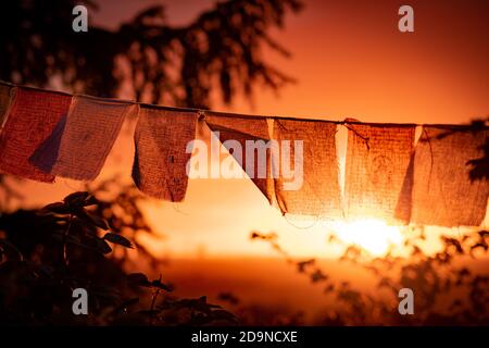 bandiere di preghiera nepalesi gialle che sventolano in luce intensa Foto Stock