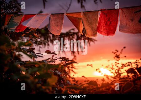 bandiere di preghiera nepalesi che sventolano durante il tramonto Foto Stock