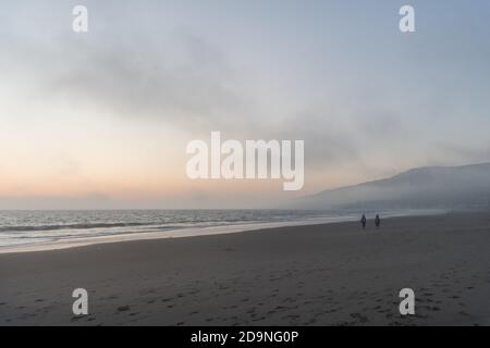 Vista panoramica di Zuma Beach dopo il tramonto in una giornata di nebbia, Malibu, California meridionale Foto Stock