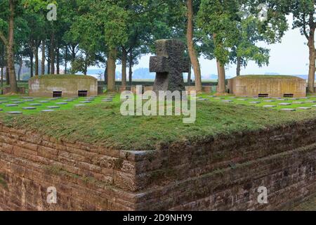 Croce di pietra e colonne della prima guerra mondiale al cimitero di guerra tedesco di Langemark al tramonto a Langemark-Poelkapelle, Belgio Foto Stock