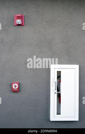 Stazione di attivazione dell'allarme antincendio manuale, estintore e avvisatore acustico/stroboscopico. Foto Stock