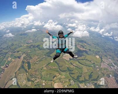 Donna Skydiver che cade in controllo seduto Foto Stock