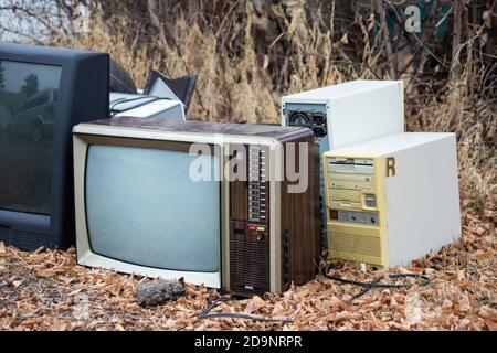 rifiuti di riciclaggio elettronico, pile di vecchi televisori, vecchi computer, vecchia tecnologia in attesa di riciclaggio Foto Stock