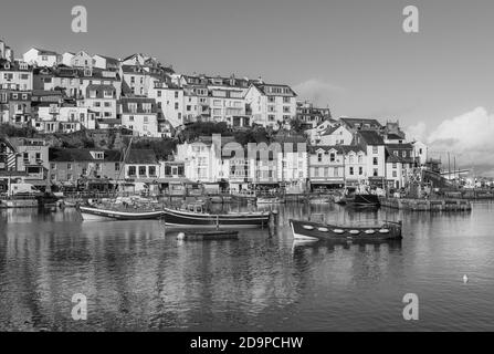 Foto in scala di grigi di barche parcheggiate nel porto vicino a. città Foto Stock