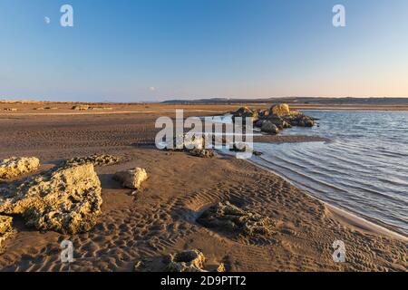 Massi di rocce che giacciono sulla costa dopo la stesa del mare Foto Stock