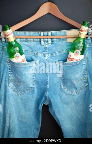 Due bottiglie di birra Budweiser verdi vuote in una tasca per pantaloni. Foto Stock