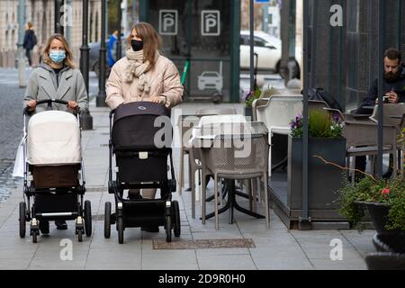 Ragazze con passeggino a piedi in città vicino a un negozio O centro commerciale durante l'epidemia di Covid o Coronavirus Foto Stock