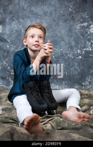 Skater giovane vestito con jeans bianchi e camicia blu ritratto dello studio Foto Stock