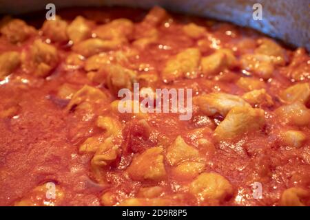 Una pentola piena di salsa di pollo, fatta solo con la salsa di pomodoro e i pezzi di pollo. Foto Stock