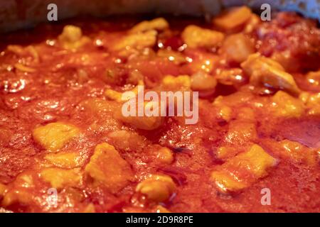 Una pentola piena di salsa di pollo, fatta solo con la salsa di pomodoro e i pezzi di pollo. Foto Stock