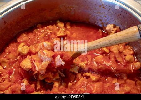 Una pentola piena di salsa di pollo, fatta solo con la salsa di pomodoro e i pezzi di pollo. Foto Stock