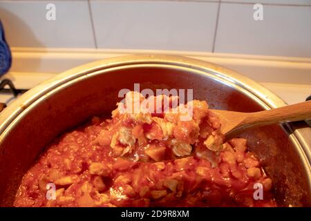 Una pentola piena di salsa di pollo, fatta solo con la salsa di pomodoro e i pezzi di pollo. Foto Stock