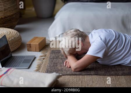 Donna anziana si rilassa in yoga asana Makarasana o coccodrillo posa Foto Stock