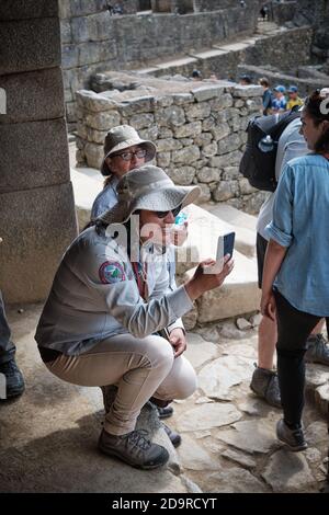 Donna in cappello scatta una foto fotografica foto foto nelle rovine a Machu Picchu, Perù Foto Stock