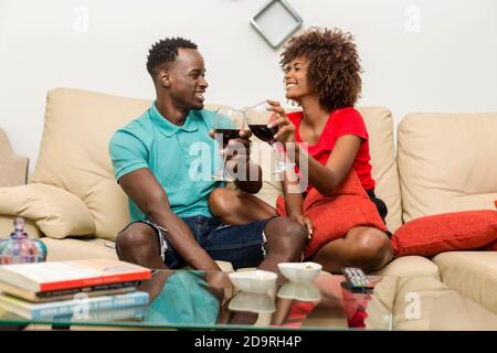 Coppia nera Africano americana bere vino nel soggiorno Foto Stock