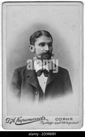 SOFIA, BULGARIA - CIRCA 1910: La carta da cabinet vintage mostra il ritratto dell'uomo di mezza età con baffi, barba piena. La foto è stata scattata in uno studio fotografico. Foto Stock