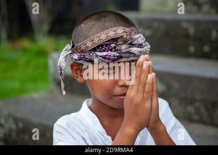 Bali, Indinesia - 04 MARZO 2013: Bambini, ragazzi, in abiti festosi e cappelli tradizionali a pura Besakih, il più grande tempio indù balinese e la maggior parte Foto Stock