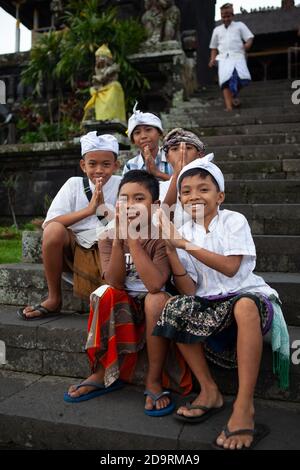 Bali, Indinesia - 04 MARZO 2013: Bambini, ragazzi, in abiti festosi e cappelli tradizionali a pura Besakih, il più grande tempio indù balinese e la maggior parte Foto Stock