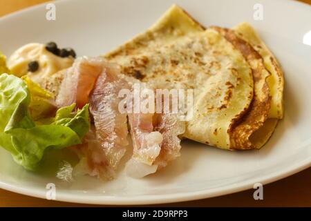 Gravlax con pancake servita foglie di insalata Foto Stock