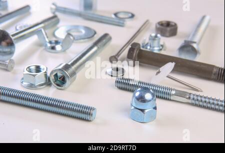 Chromeplated bulloni e dadi su sfondo bianco Foto Stock