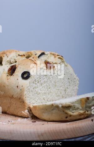 Focaccia con olive e pomodori secchi. Su uno sfondo chiaro. Primo piano. Foto Stock