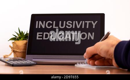 Concetto di educazione e inclusività. Tablet con testo "Inclusivity Education". Formazione online durante la quarantena COVID-19. Mano maschile con penna, calcolatrice Foto Stock