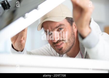 Repairman installazione fornello ad induzione in cucina Foto Stock