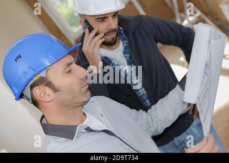 ingegneri maschi che utilizzano il telefono cellulare nel cantiere Foto Stock