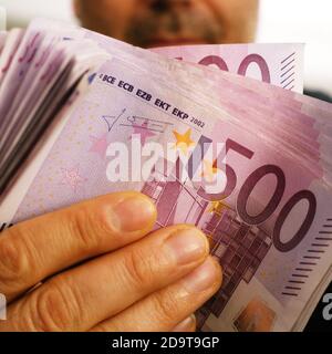 un uomo ricco mostra 10,000 euro in 500 euro di banconote Foto Stock