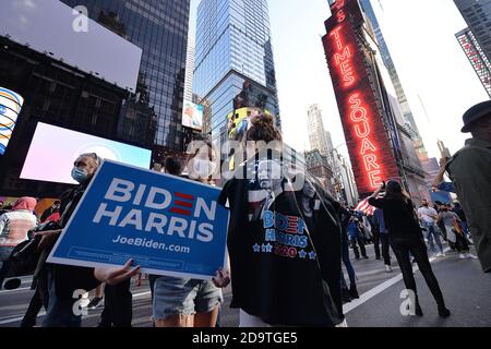 New York City, Stati Uniti. 07 novembre 2020. Una giovane donna tiene i segni di Biden/Harris e il suo amico indossa una t-shirt Biden/Harris mentre celebrano in Times Square dopo che i media dichiarano Joe Biden come il vincitore delle elezioni presidenziali degli Stati Uniti 2020, New York, NY, 7 novembre 2020. Il democratico Joe Biden ha sconfitto il presidente Donald Trump diventando il 46° presidente degli Stati Uniti dopo che Biden ha vinto la Pennsylvania con 20 voti elettorali". (Anthony Behar/Sipa USA) Credit: Sipa USA/Alamy Live News Foto Stock