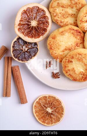 Frittelle di formaggio di cottage. Colazione di Natale con anice e cannella su sfondo bianco, vista dall'alto Foto Stock