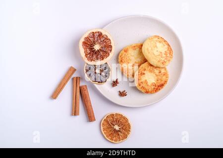 Frittelle di formaggio di cottage. Colazione di Natale con anice e cannella su sfondo bianco, vista dall'alto Foto Stock