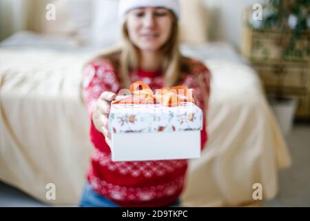 Donna con le mani in mano tenere il Natale o il nuovo anno decorato confezione regalo. Foto Stock
